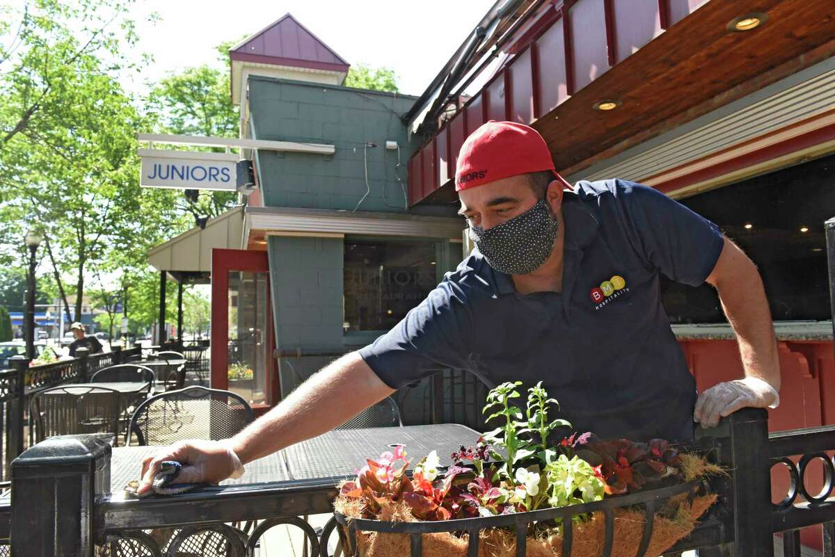 Brian Viglucci, co-owner of Juniors, cleans and sets up for outdoor dining which reopens today on Thursday, June 4, 2020 in Albany, N.Y. (Lori Van Buren/Times Union)