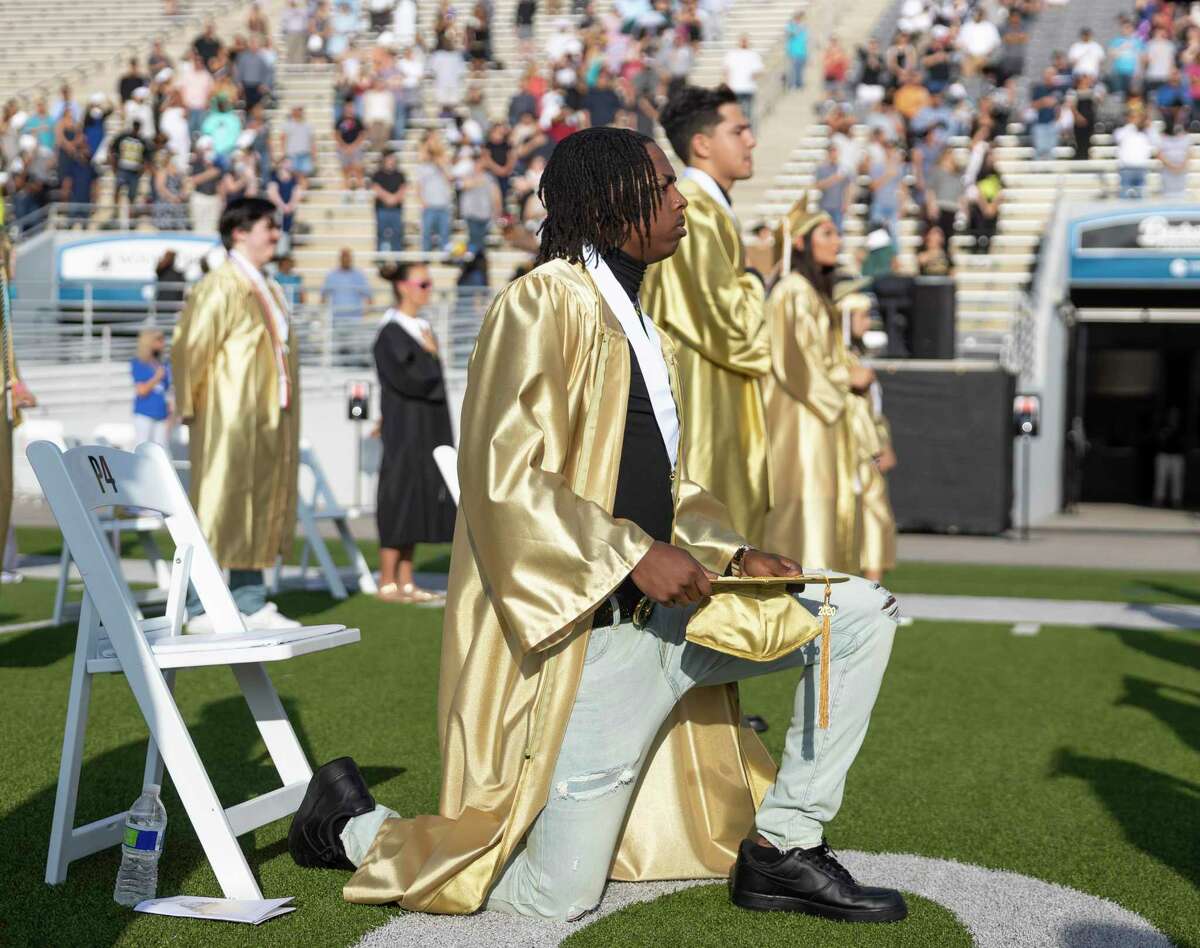 Dyterrius Deshaun Ellis takes a knee during the playing of the national anthem at a Conroe High School graduation ceremony held at Woodforest Bank Stadium in Shenandoah, Thursday, June 4, 2020. Graduates and families were asked to practice social distancing to prevent any spread of the COVID-19 virus.