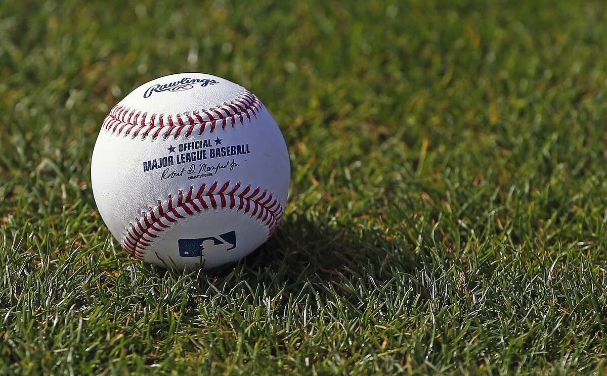 FILE - In this Feb. 17, 2017, file photo, a baseball is shown on the grass at the Cincinnati Reds baseball spring training facility in Goodyear, Ariz. Major League Baseball rejected the players' offer for a 114-game regular season in the pandemic-delayed season with no additional salary cuts and told the union it did not plan to make a counterproposal, a person familiar with the negotiations told The Associated Press. The person spoke on condition of anonymity Wednesday, June 3, 2020, because no statements were authorized. (AP Photo/Ross D. Franklin, FIle)