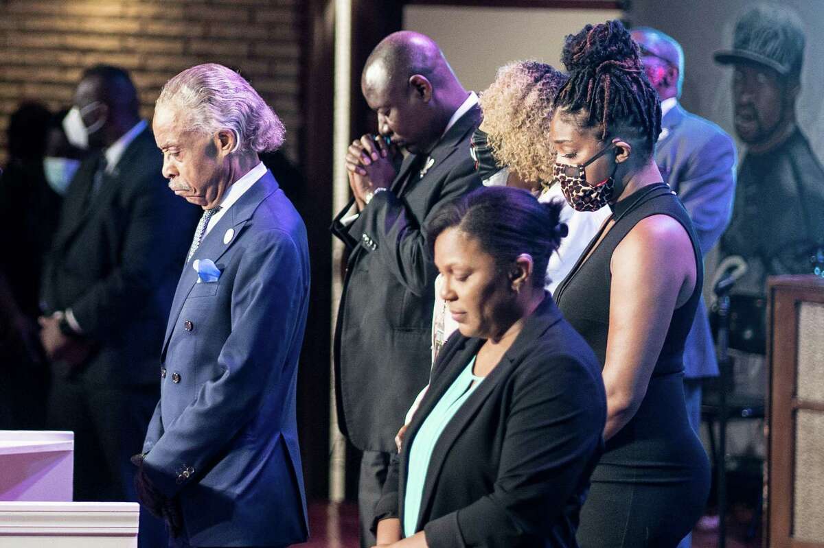 US civil rights leader Al Sharpton, left, stands with others as they bow their heads during a memorial service in honor of George Floyd on June 4, 2020, at North Central University's Frank J. Lindquist Sanctuary in Minneapolis, Minnesota.