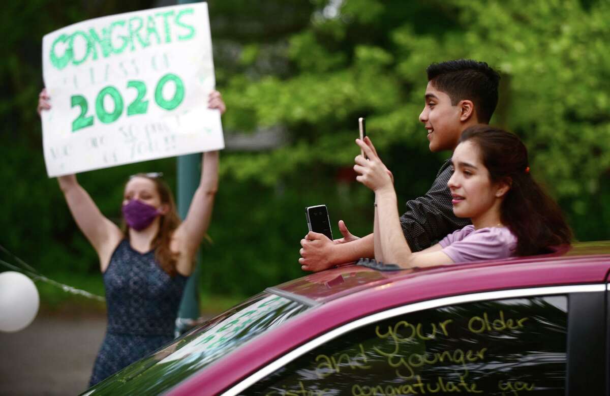 8th grade students from West Rocks Middle School receive congratulations from the staff Thursday, June 4, 2020, during a drive-thru graduation ceremony at the school in Norwalk, Conn.