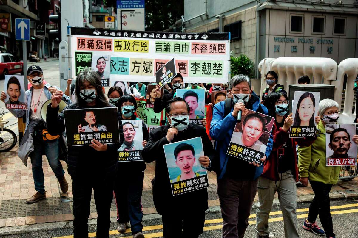 Pro-democracy protesters from HK Alliance hold placards of detained rights activists as they march towards the Chinese liaison office in Hong Kong on February 19, 2020, in protest against Beijings detention of prominent anti-corruption activist Xu Zhiyong. - Police in China have arrested Xu Zhiyong, a prominent anti-corruption activist who had been criticising President Xi Jinpings handling of the COVID-19 coronavirus. (Photo by ISAAC LAWRENCE / AFP) (Photo by ISAAC LAWRENCE/AFP via Getty Images)