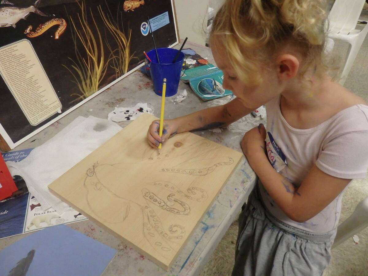 Camper working on Octopus on pine board 2019 Milford Marine Institute Marine Biology Science/Art Camp