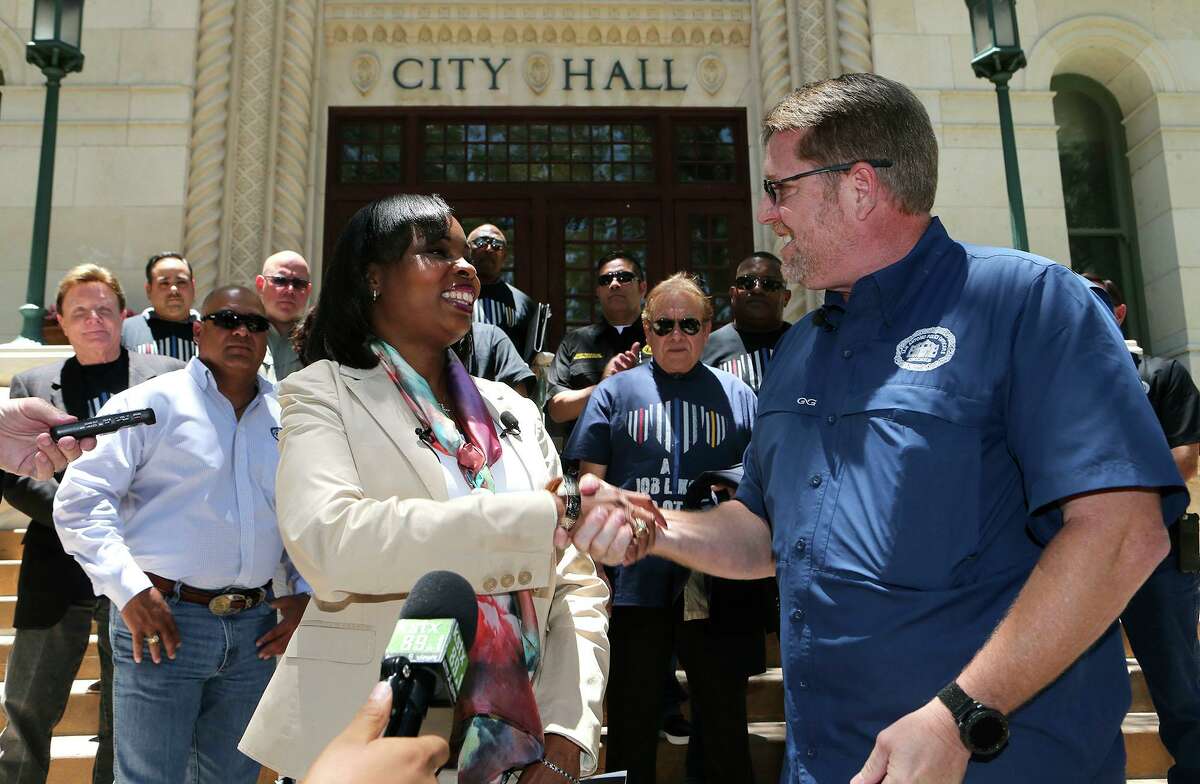 San Antonio Police Officers Association President Mike Helle (right, foreground) shakes hand with San Antonio Mayor Ivy Taylor in 2017 in front of city hall after announcing the association's support for Taylor as a mayoral candiddate.