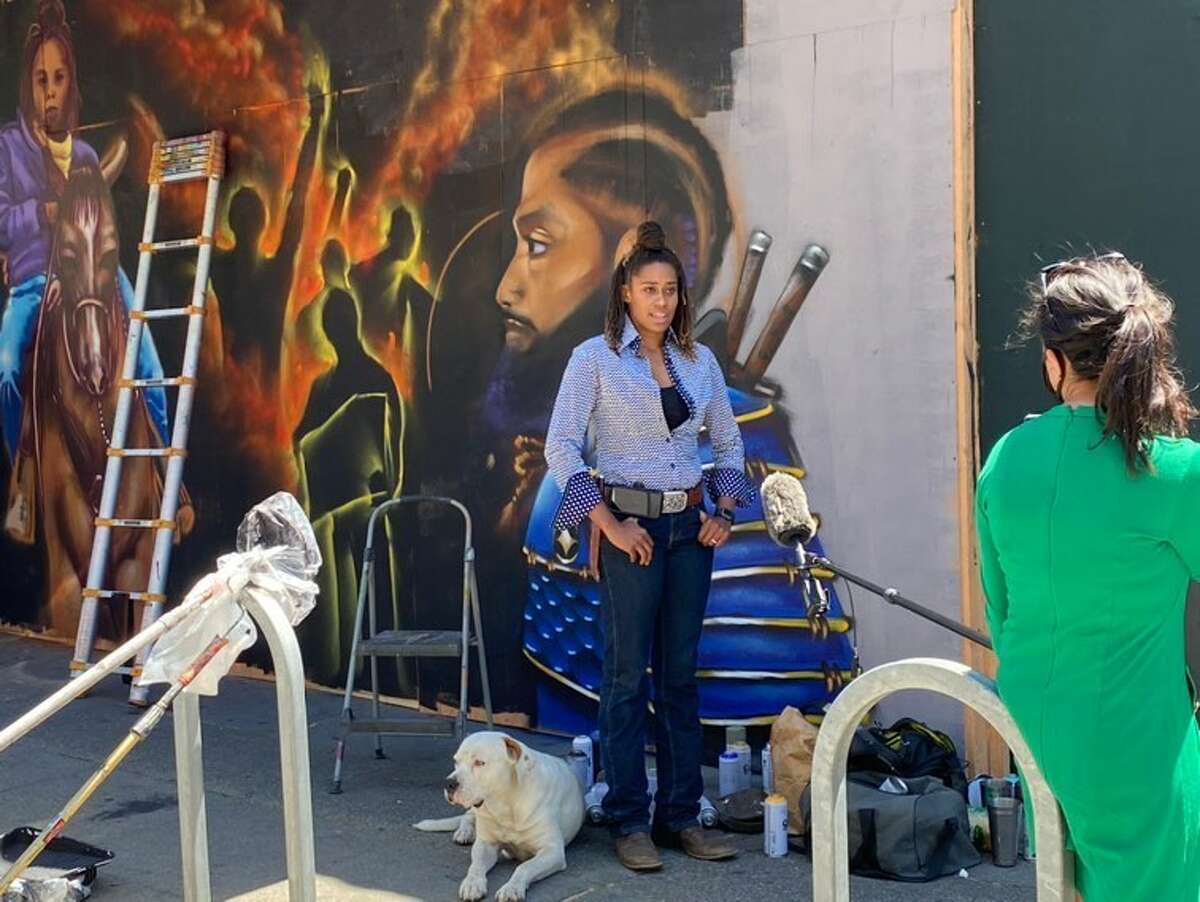 On Thursday, the mural was finished: A fiery scene of shadowed revolutionaries holding fists, signs, and flags to the air, with Brianna Noble on horseback as the centerpiece. A portrait of Nipsey Hussle looks on from the far right of the mural. 