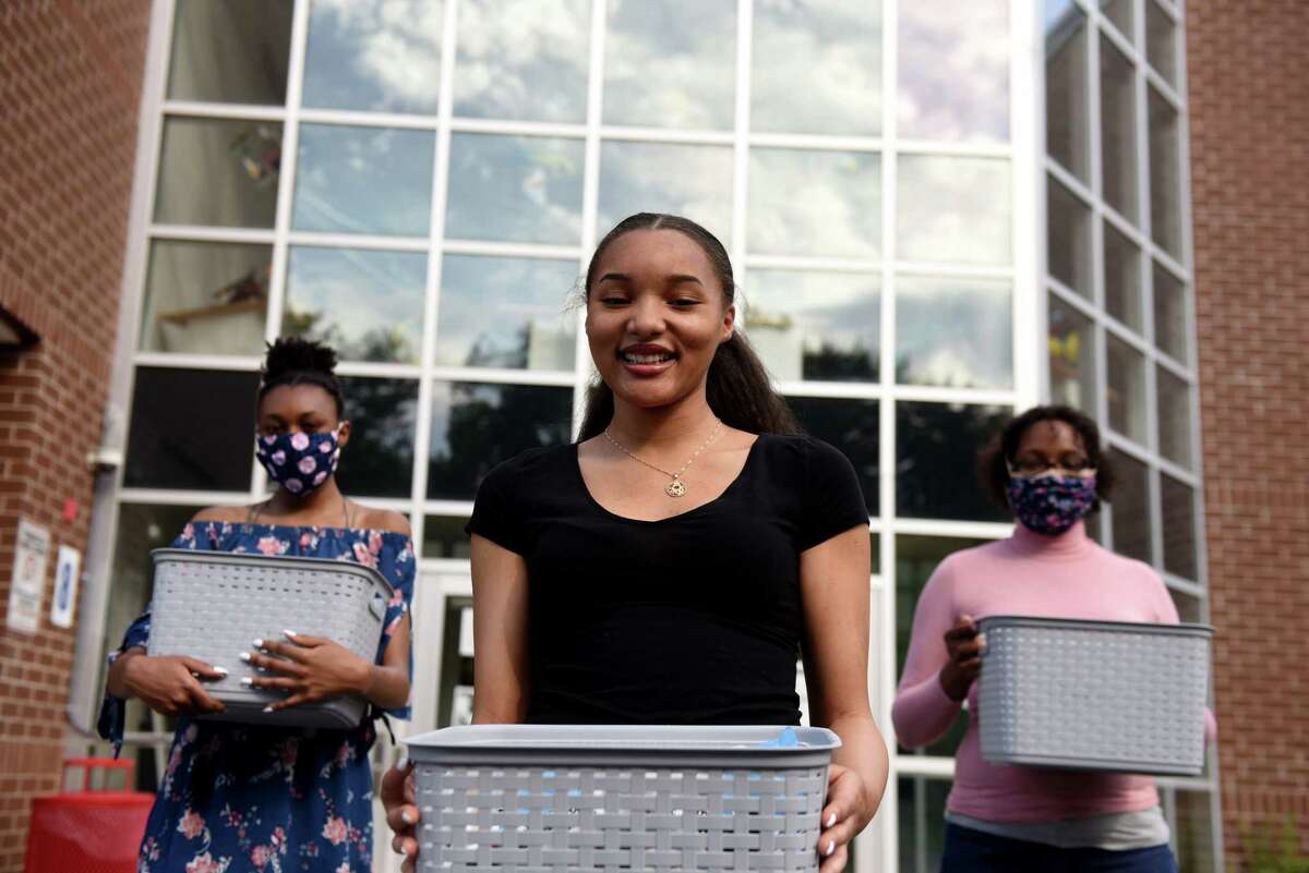 Graduating Schenectady High School senior Kini-Analysa McCalmon, center, is pictured with her sister, Zilya, 14, left, and mother, Thearse McCalmon, right, on Thursday, June 4, 2020, in Schenectady, N.Y. Kini-Analysa made face masks and assisted her community in overcoming coronavirus hardships. (Will Waldron/Times Union)