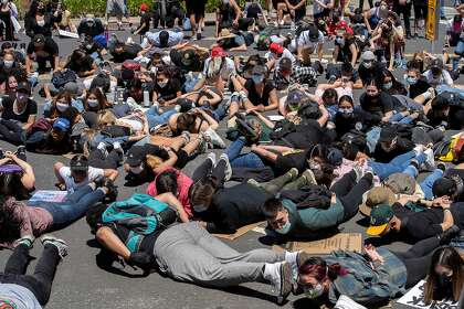 Protestors chant “I can’t breathe” during a protest demanding justice for George Floyd outside the Municipal Services Building in South San Francisco on Thursday. Social distancing was not practiced during many protests.