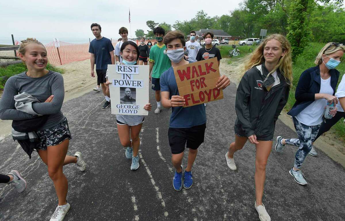Caroline Yu and Javier Serra, a Greenwich High School student, hold signs as they lead a couple hundred students and residents on a walk through Greenwich Point on June, 5, 2020 in Greenwich, Connecticut. Serra organized the event to protest the senseless death of George Floyd, have participant walk over eight miles to represent the eight minutes that former Minneapolis Police officer Derek Chauvin pressed his knee into Floyd's neck. Greenwich Police officers escorted the peaceful march through the streets of Greenwich and Old Greenwich.