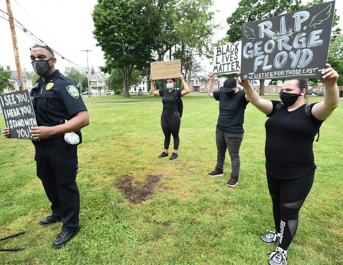 East Haven Police Lt. Joseph Murgo, left, and approximately 250 people gathered at a rally with Black Lives Matters supporters and the East Haven Police Department standing with demonstrators speaking out against police brutality last week on the East Haven Green.