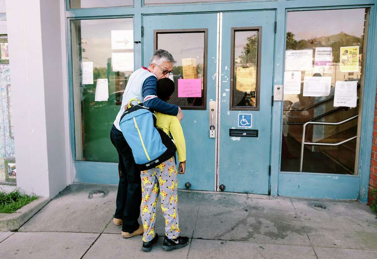Willie Ramirez kisses his son Akeem Ramirez, 8, goodbye during the morning drop-off at Harvey Milk Civil Rights Academy back in early March, before San Francisco’s shelter-inplace order.
