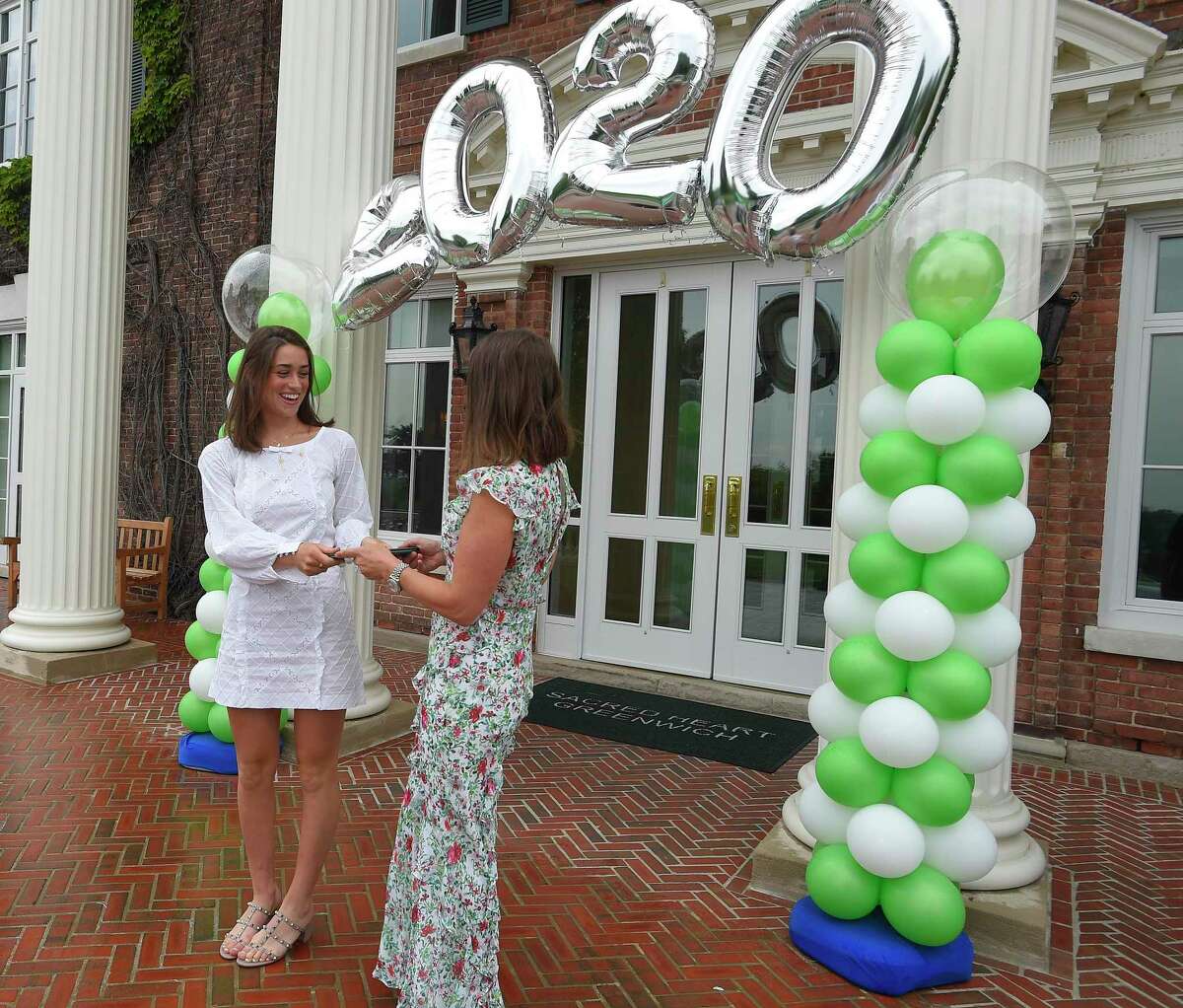 Emma Caruso and her mother Sandra Caruso, a trustee at Sacred Heart Greenwich, pose for a photograph as the Class of 2020 celebrates with a Graduation Parade at the school in Greenwich, Connecticut on June 5, 2020. Each Senior was presented with their diplomas and had a photograph taken with a celebratory display in front of the school's Salisbury Hall. After distance learning to close the year due to the coronavirus, Greenwich’s private schools have set Sept. 8 to reopen with flexible plans to try and get students back on campus if it is safe.