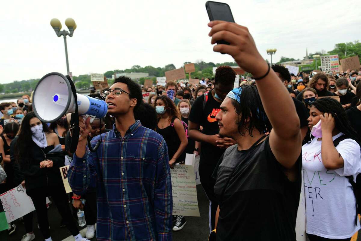 Black Lives Matter and several current and formet Staples High School students including Chet Ellis join a group of protestors Friday, June 5, 2020, in downtown Westport, Conn. The group marched from the Post Road bridge to the police station in a peaceful protest against police brutality.