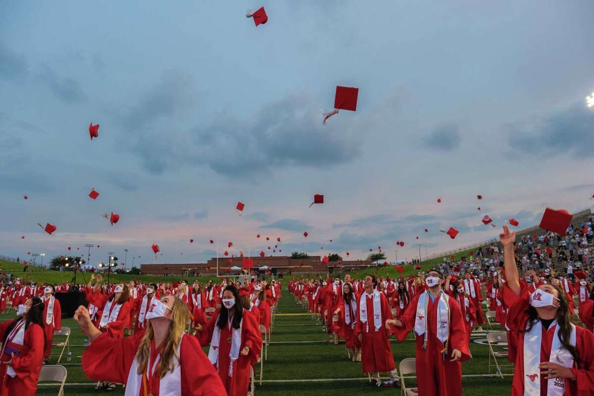 Memorial High School class of 2020 graduates throw their caps in the air at the conclusion of the graduation ceremony at Darrell Tully Stadium on June 1