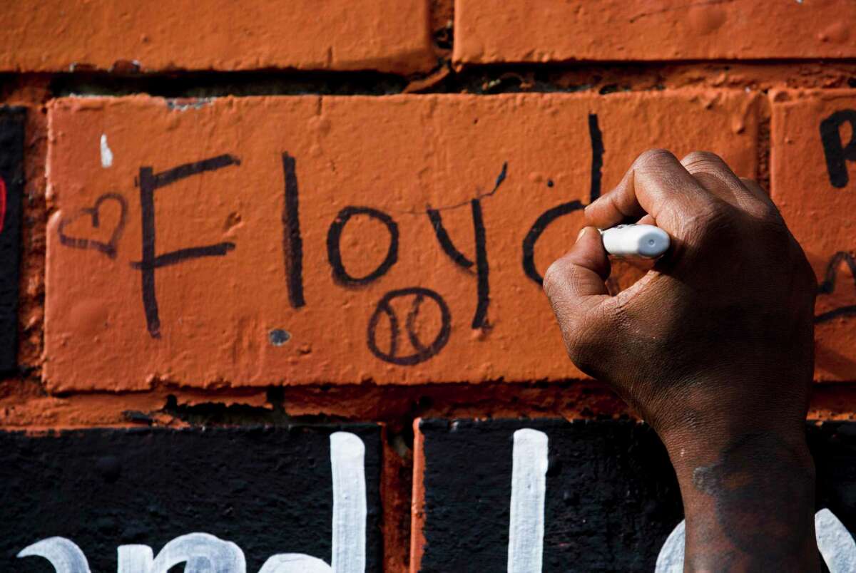 Cal Wayne writes Floyd on "The Wall," which serves as a memorial for Cuney Homes residents in Houston’s Third Ward who have died. Wayne grew up with Floyd, who died in custody of Minneapolis Police officers May 25.