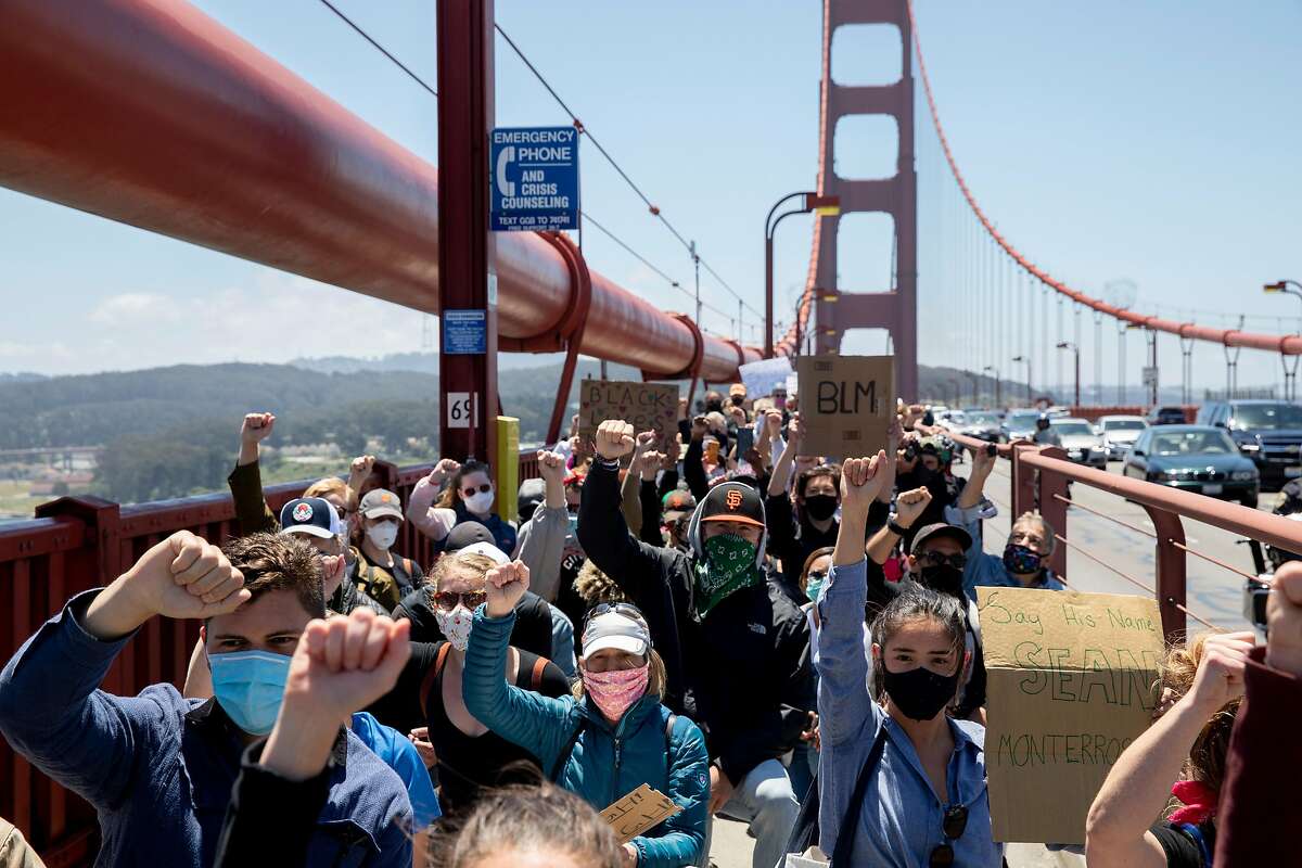 Thousands of demonstrators raise their fists and pause to take a knee as they make their way across the Golden Gate Bridge in San Francisco, Calif. Saturday, June 6, 2020 during a march in support of the Black Lives Matter movement.