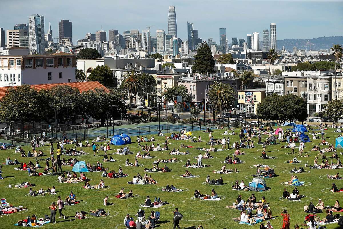 People socialize in the social distancing circles at Mission Dolores Park in San Francisco, Calif., on Sunday, May 24, 2020.