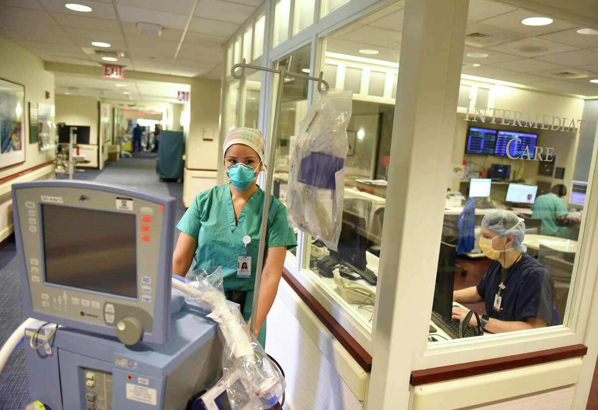 Respiratory therapist Jennyfer Ramirez poses with a ventilator in the intensive care unit where coronavirus patients are being treated at Greenwich Hospital in Greenwich, Conn. Thursday, May 14, 2020.