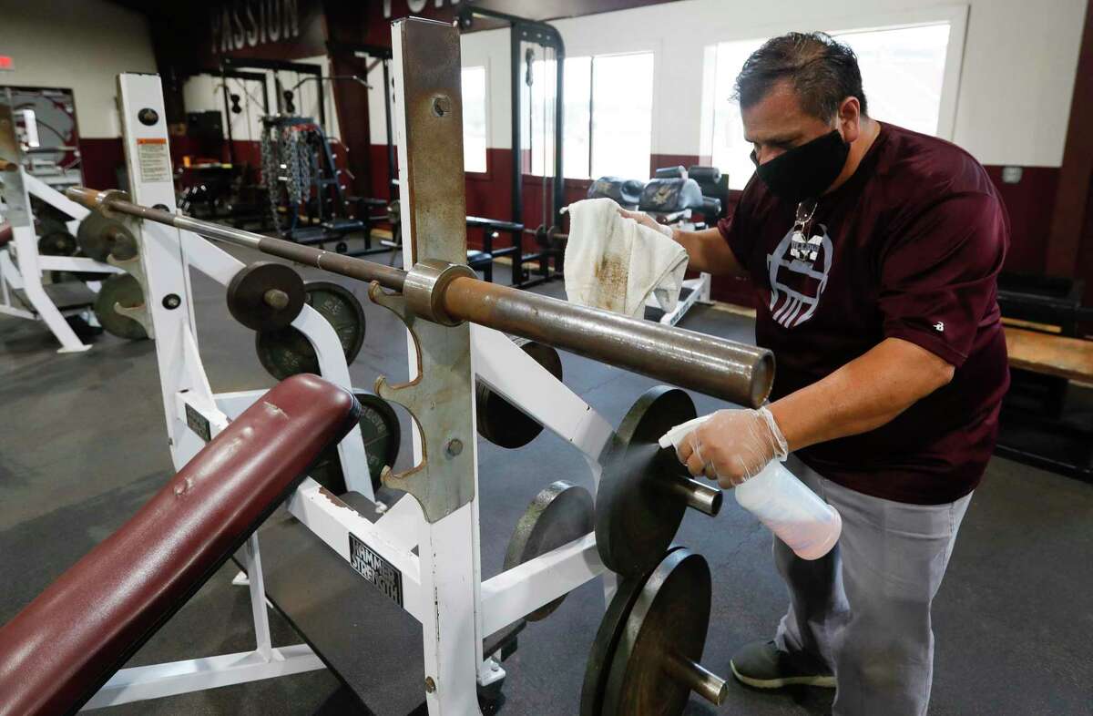 Custodian Phillip Ramirez helps clean and sanitize the weight room at Magnolia High School, Tuesday, June 2, 2020, in Magnolia. UIL schools are allowed to open strength and conditioning sessions to athletes starting Monday, June 8, under social distancing and other safety guidelines.