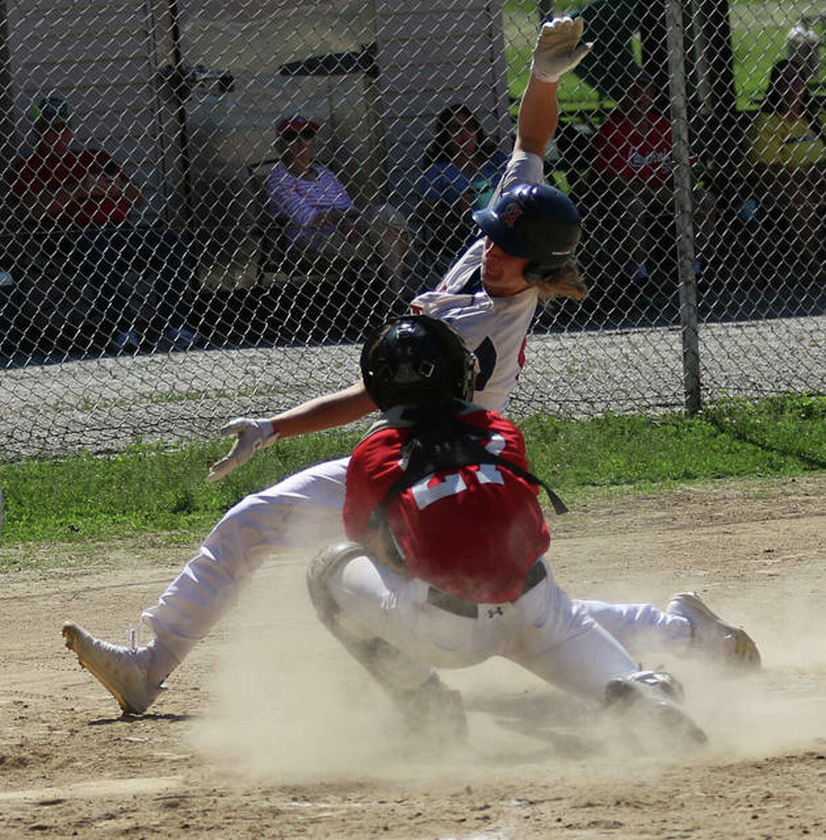 Alton’s John Durrwachter (back) cannot elude the tag from Highland’s catcher and is out on a play at the plate in the first game of a doubleheader Sunday at P.I.C. Park in Pierron.