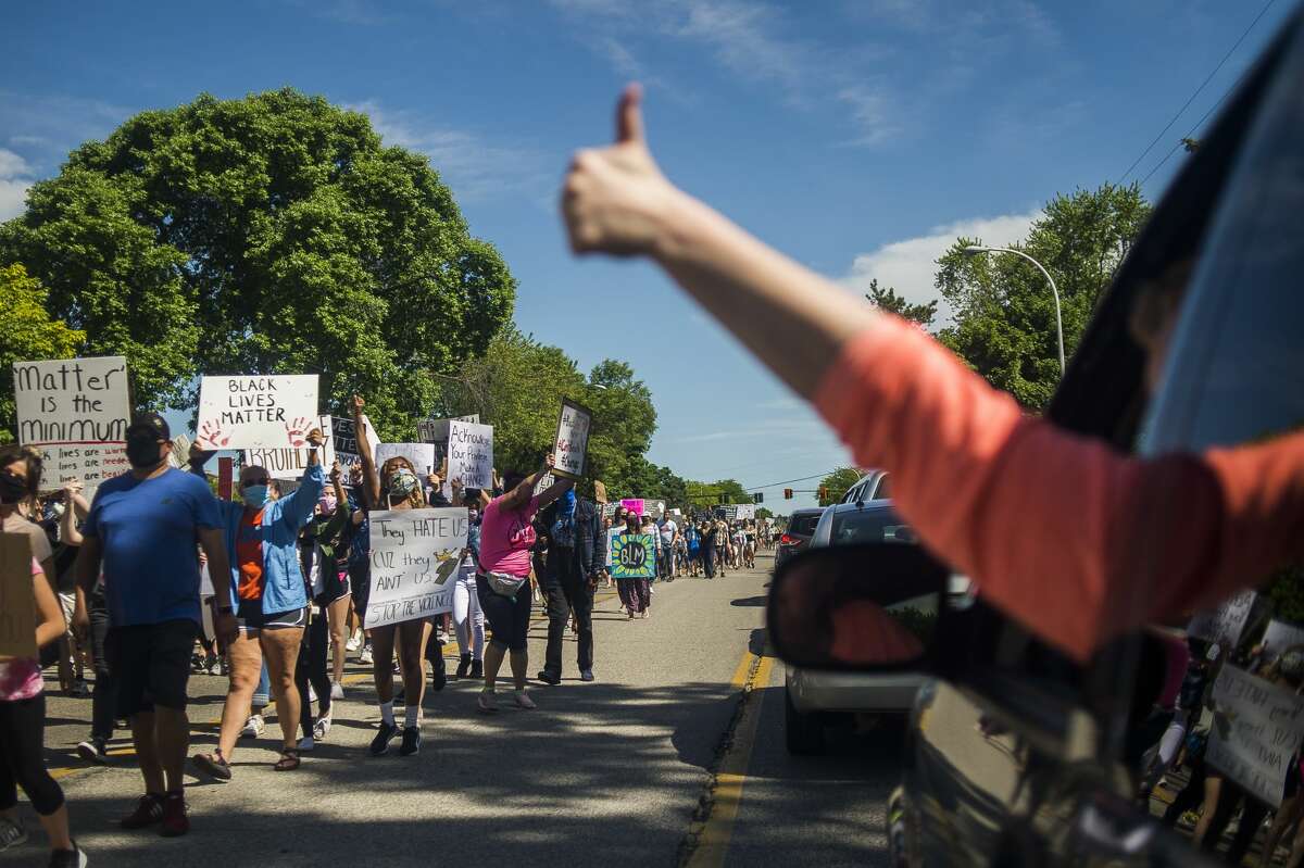 Approximately 1,200 people gather for a rally for racial justice Sunday, June 7, 2020 in Midland. The group gathered at Ashman Circle before marching down Saginaw Road until they reached Eastlawn Drive, turned around and marched back. (Katy Kildee/kkildee@mdn.net)