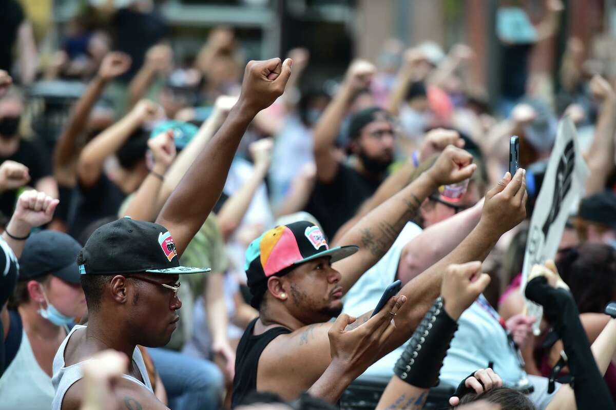 Marchers raise their fists during a vigil for Charles “Chop” Roundtree and Marquise Jones, black men who were killed by San Antonio police officers.