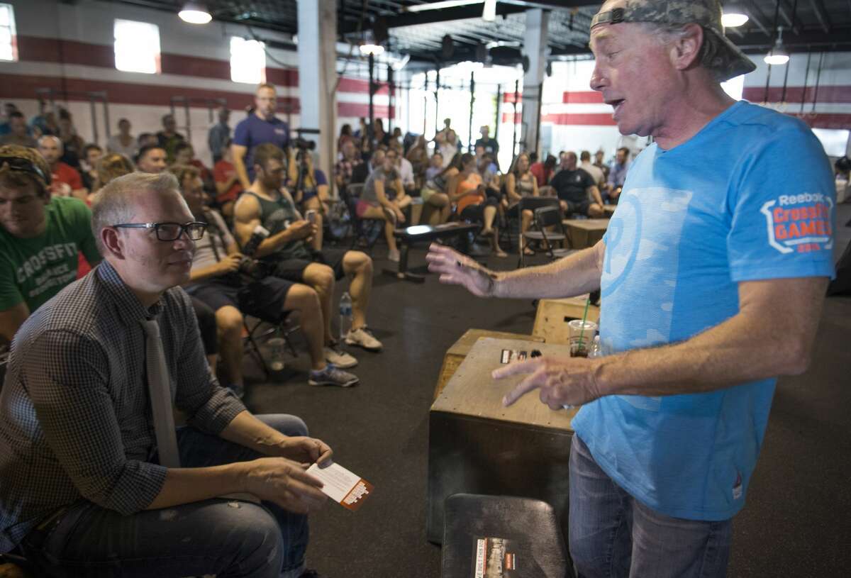 Crossfit Inc. founder and CEO Greg Glassman (right) talks to employees prior to a presentation at the Half street location in Washington, DC on July 31, 2015. Glassman received criticism for a tweet about the coronavirus pandemic and George Floyd.