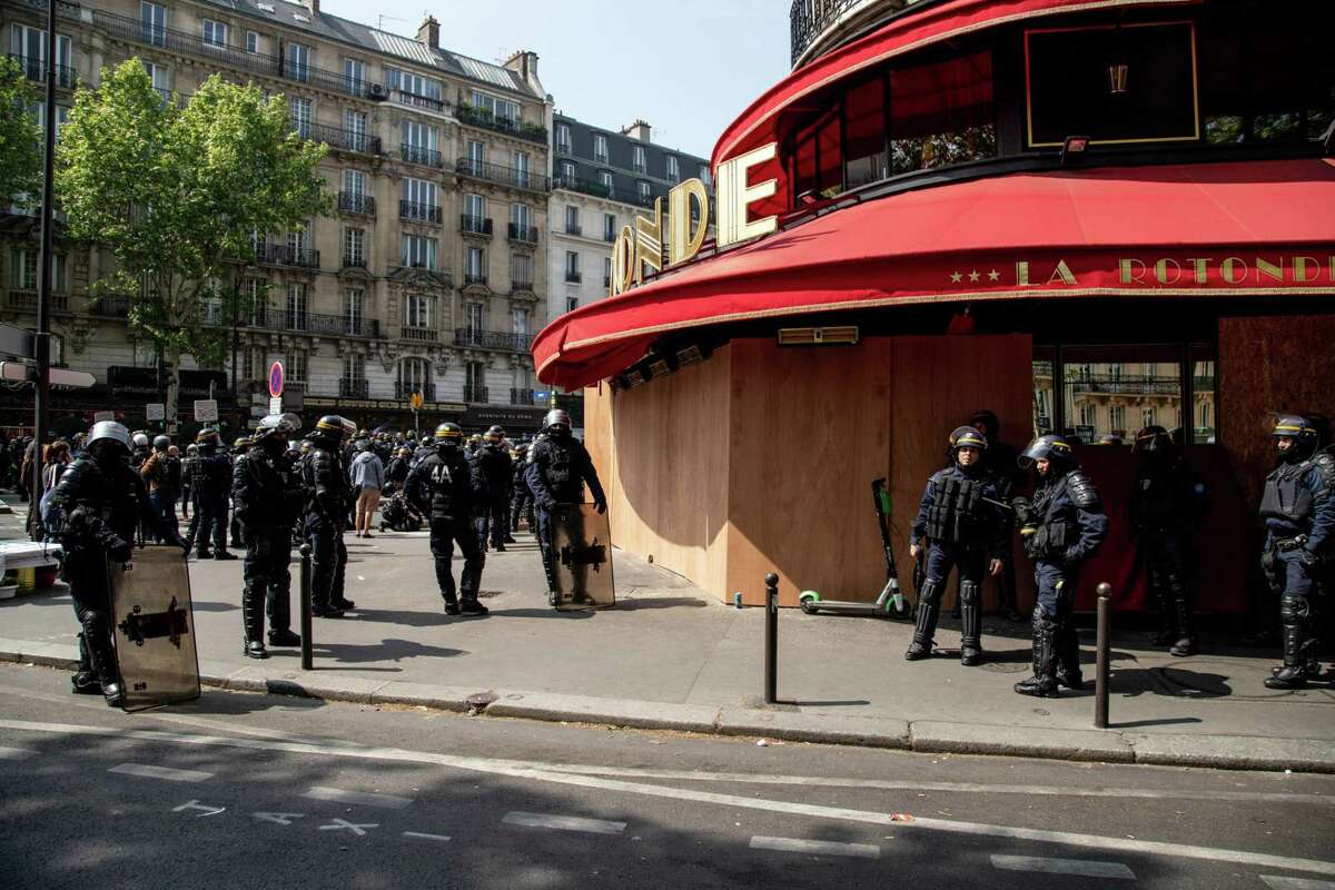 Gendarmes in riot gear stand outside the boarded-up La Rotonde cafe on International Workers' Day in Paris on May 1, 2019.