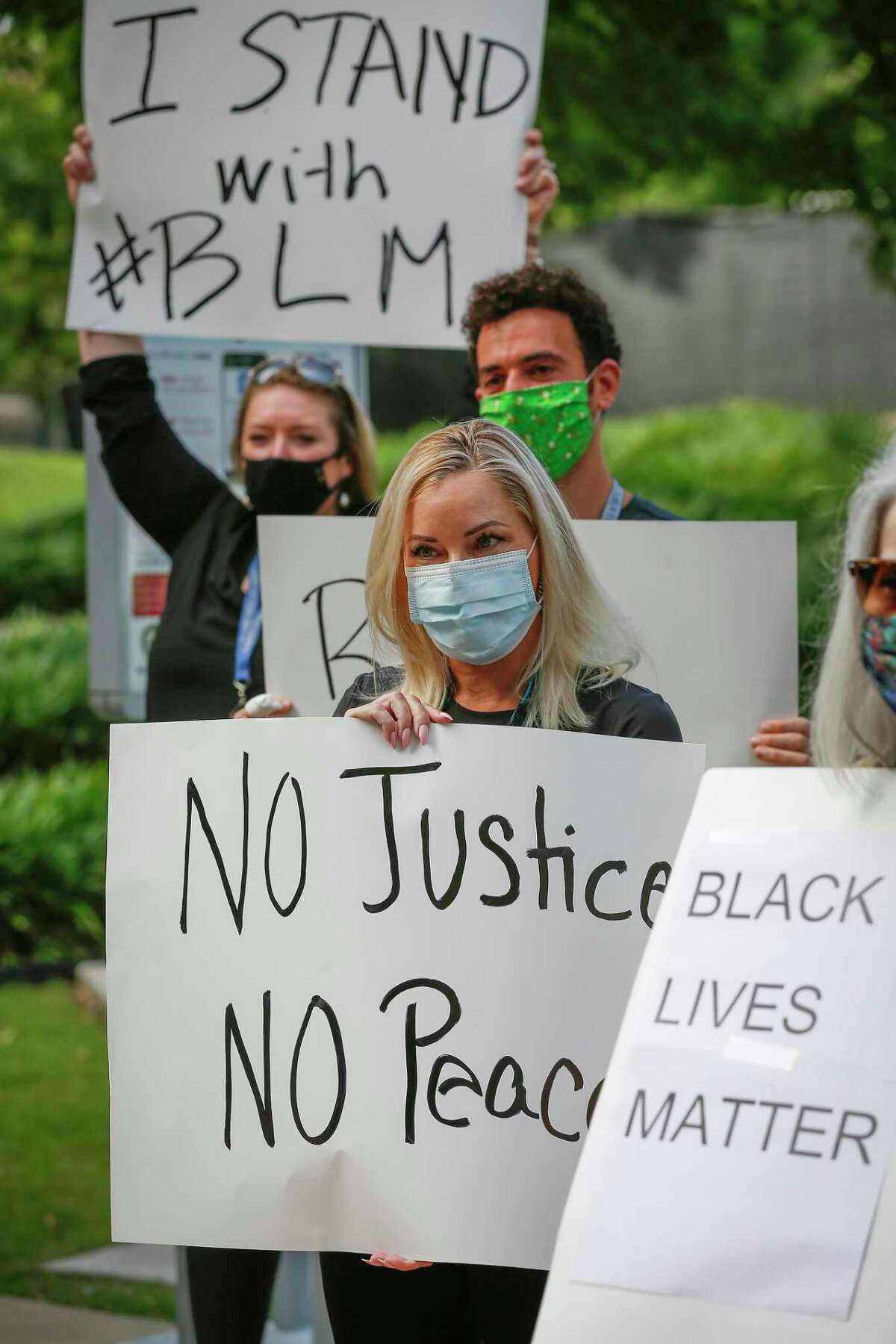 Mary Ruden holds a sign as she joined other Harris County Public Defenders as they gathered in support of black lives matter across from the Harris County Criminal Justice Center Monday, June 8, 2020, in Houston.