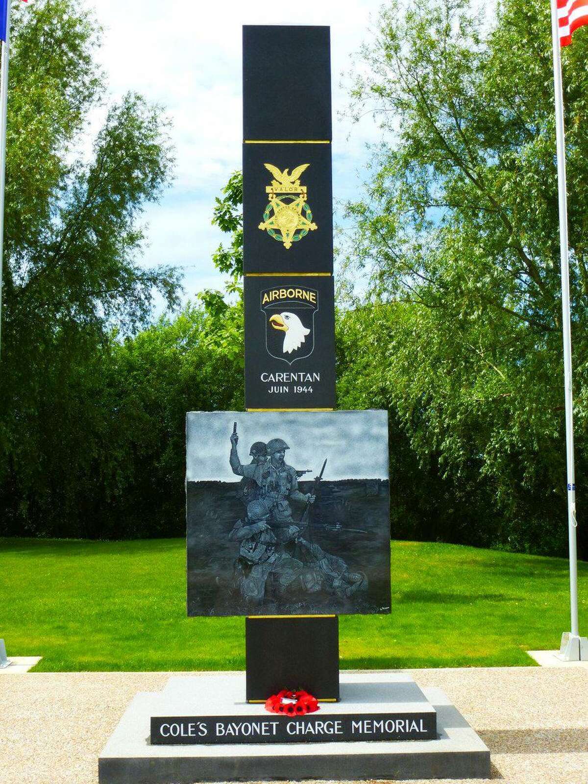 A dark stone monolith with an engraved Medal of Honor and the 101st Airborne Unit insignia is at the spot in France where Lt. Col. Robert Cole led his battalion in a bayonet charge after being hopelessly pinned down to drive back the enemy and secure the approach to Carentan. Cole was awarded the Medal of Honor for his actions here.