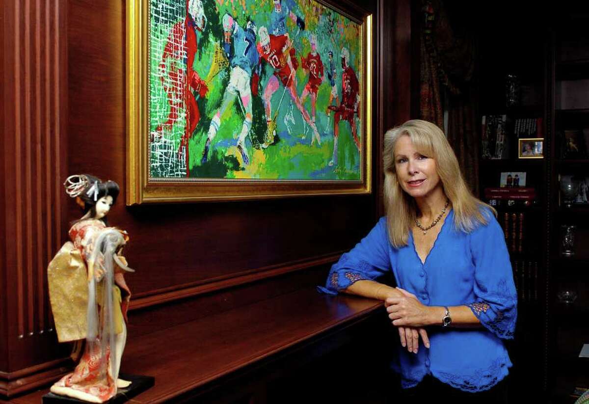 Bonnie McEneaney stands by a painting by LeRoy Neiman of her husband playing lacrosse in the den of her home in New Canaan, Conn. on Monday August 23, 2010. McEneaney has written a book, titled Messages, about premonitions or signs that she says 9/11 victims have sent their still-living family from beyond, her husband, Eamon, was killed in the WTC.