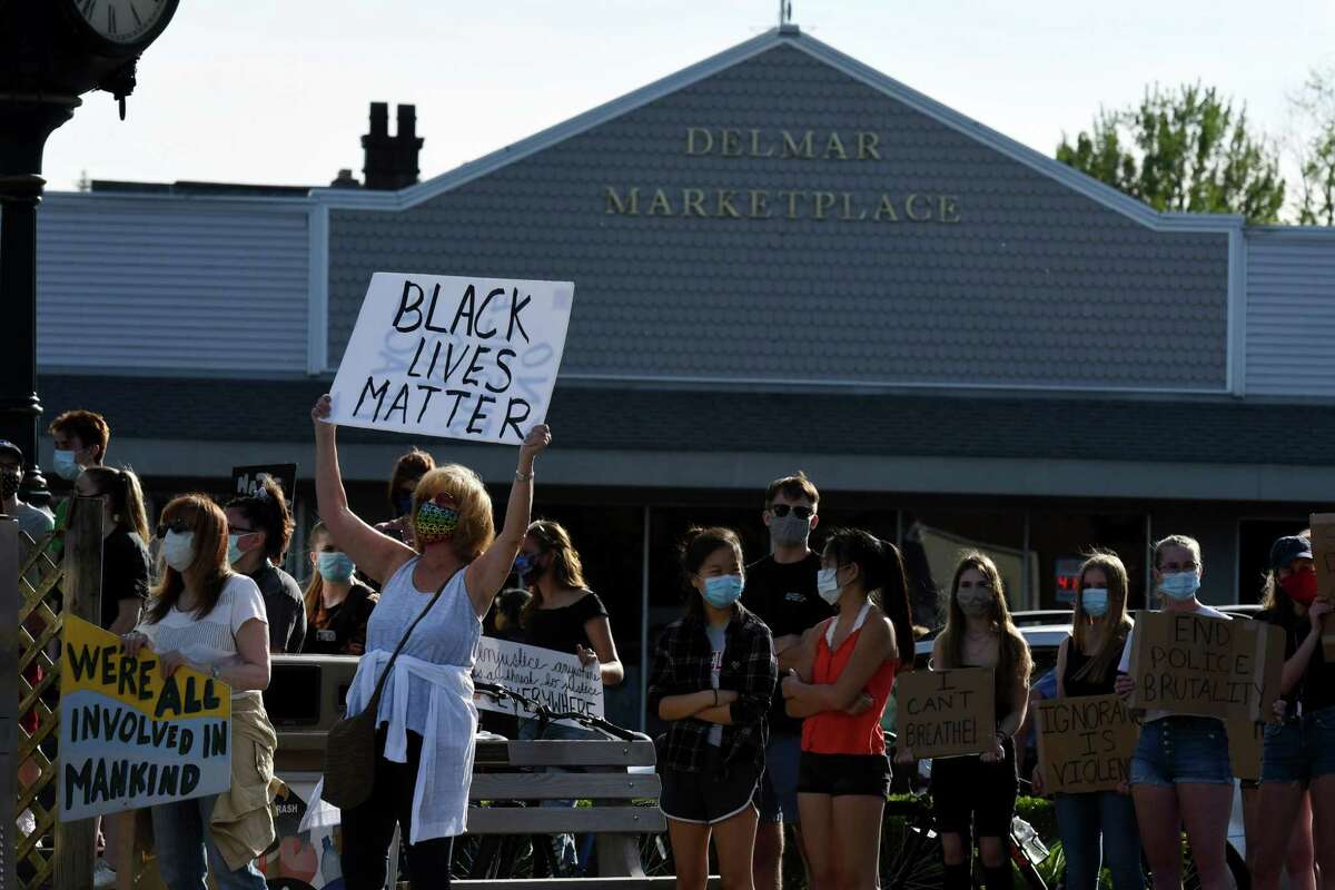 People gather in solidarity at the Four Corners during a vigil to protest against police brutality and inequality in the wake of the death of George Floyd on Monday, June 8, 2020, in Delmar, N.Y. (Will Waldron/Times Union)