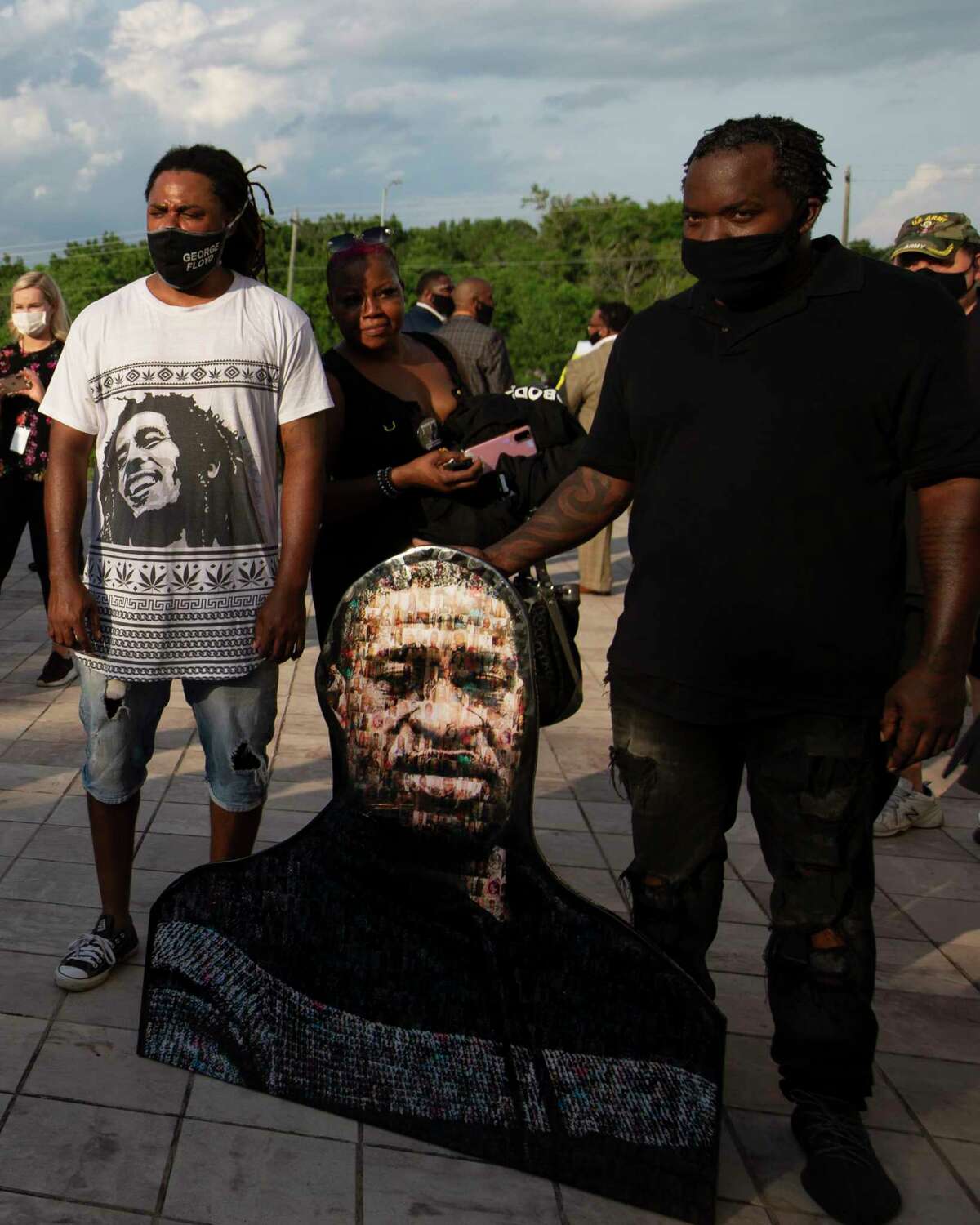 People bring a photo mosaic of George Floyd to the public mamorial for him Monday, June 8, 2020, at The Fountain of Praise Church in Houston.