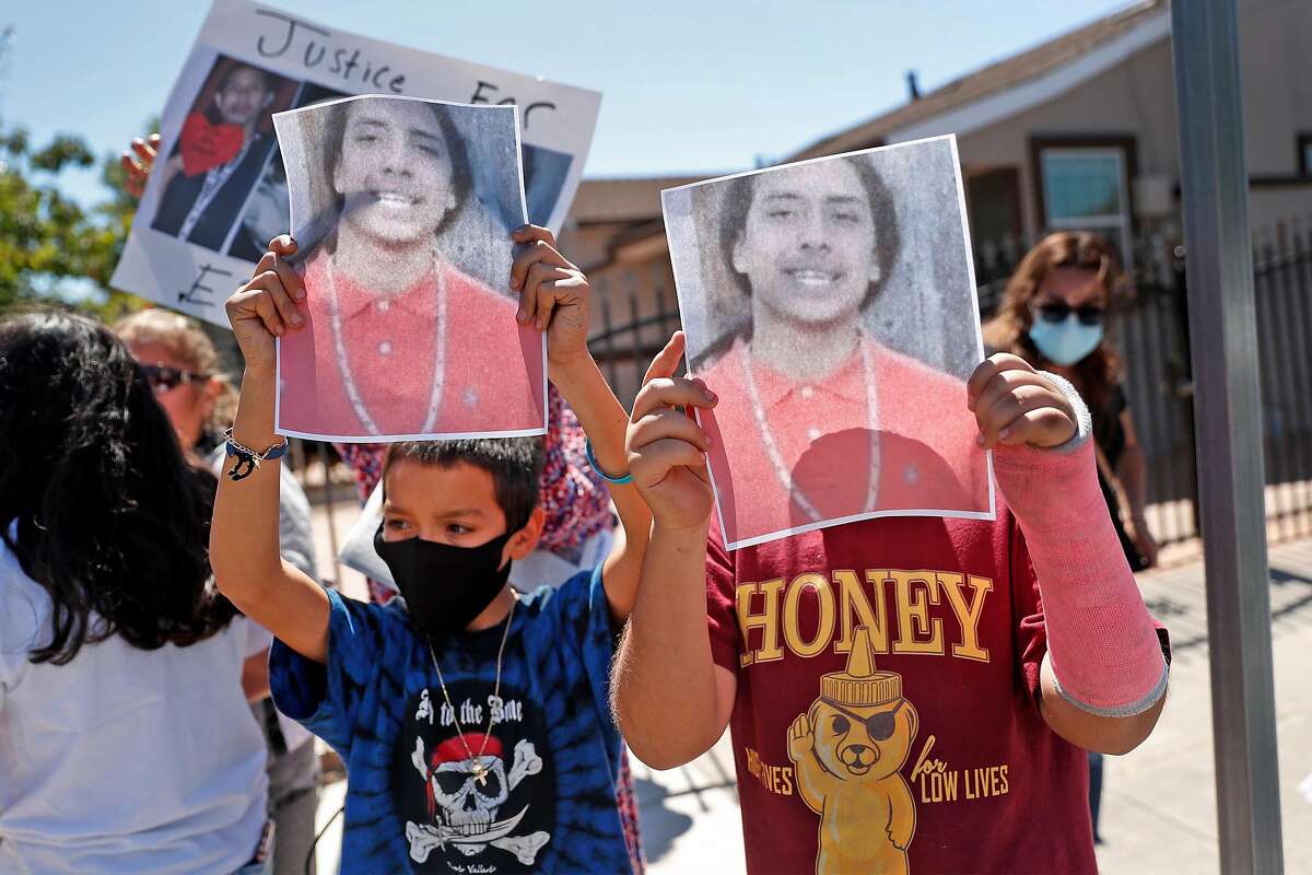 Erik Salgado's cousins Angel Guzman, 11, (left) and Eric Beltran, 11, hold up photos of Salgado as people gather at Elmhurst Middle School to protest the death of and memorialize the life of Salgado, who was killed in a CHP officer-involved shooting Saturday night. Photographed in Oakland, Calif., on Monday, June 8, 2020.