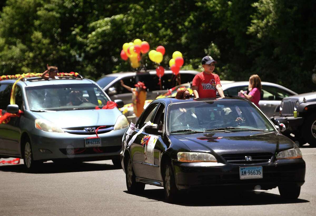Sunnyside School teachers greet an automobile parade of students and their parents to mark the end of the school year on Monday.
