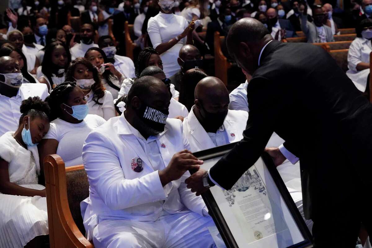 Houston Mayor Sylvester Turner hands the family a proclomation family and guests attend the funeral service for George Floyd at The Fountain of Praise church Tuesday, June 9, 2020, in Houston.
