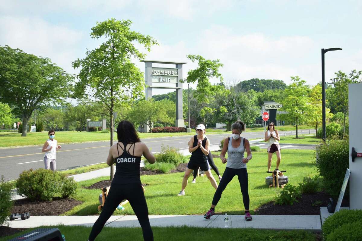 FluxFit owner Alyssa Buckheit leads an outdoor fitness workout at her newly opened center across from Danbury Fair in Danbury, Conn. FluxFit is one of a number of fitness centers throughout Connecticut that have been offering outdoor or virtual sessions during hiatuses forced by the COVID-19 epidemic.