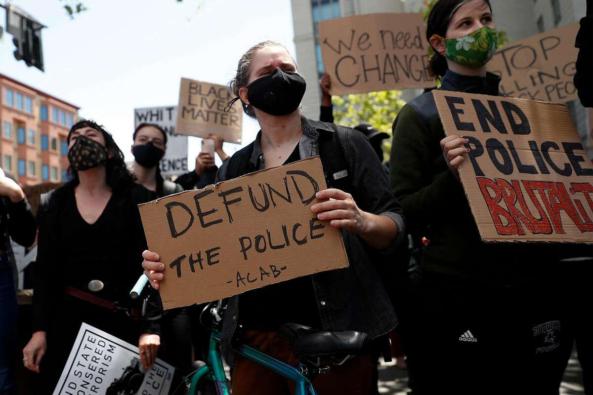 A protester holds a Defund the Police sign outside Oakland Police Headquarters in Oakland, Calif., on Sunday, June 7, 2020.