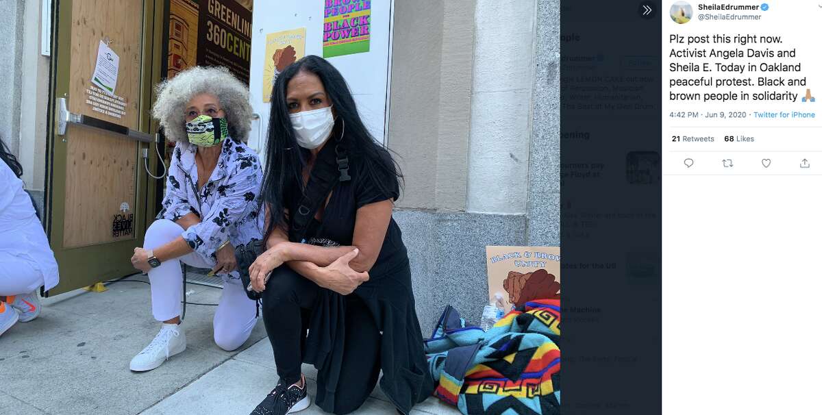 FILE - Sheila E. kneels next to Angela Davis at a Black Lives Matter demonstration in Oakland on June 9, 2020.