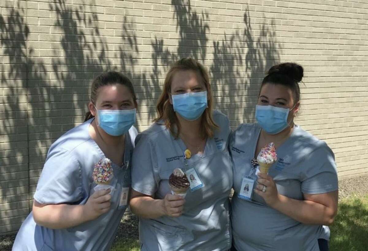 Emily Plavcan, Jennifer Cronin and Ashley Pannese, all physical therapists at the Milford Campus of Bridgeport Hospital, take a break to enjoy an ice cream supplied by Mr. Softee on the one-year anniversary of the hospitals coming together.