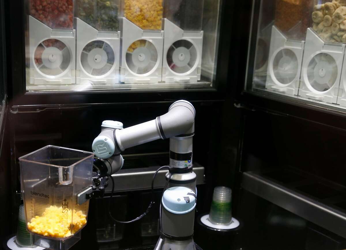 An automated smoothie-making kiosk developed by Blendid handles a pitcher of mangos in a test run at the Market Cafe on the USF campus in San Francisco, Calif. on Friday, March 22, 2019. The robotic smoothie kiosk goes fully operational on Monday.