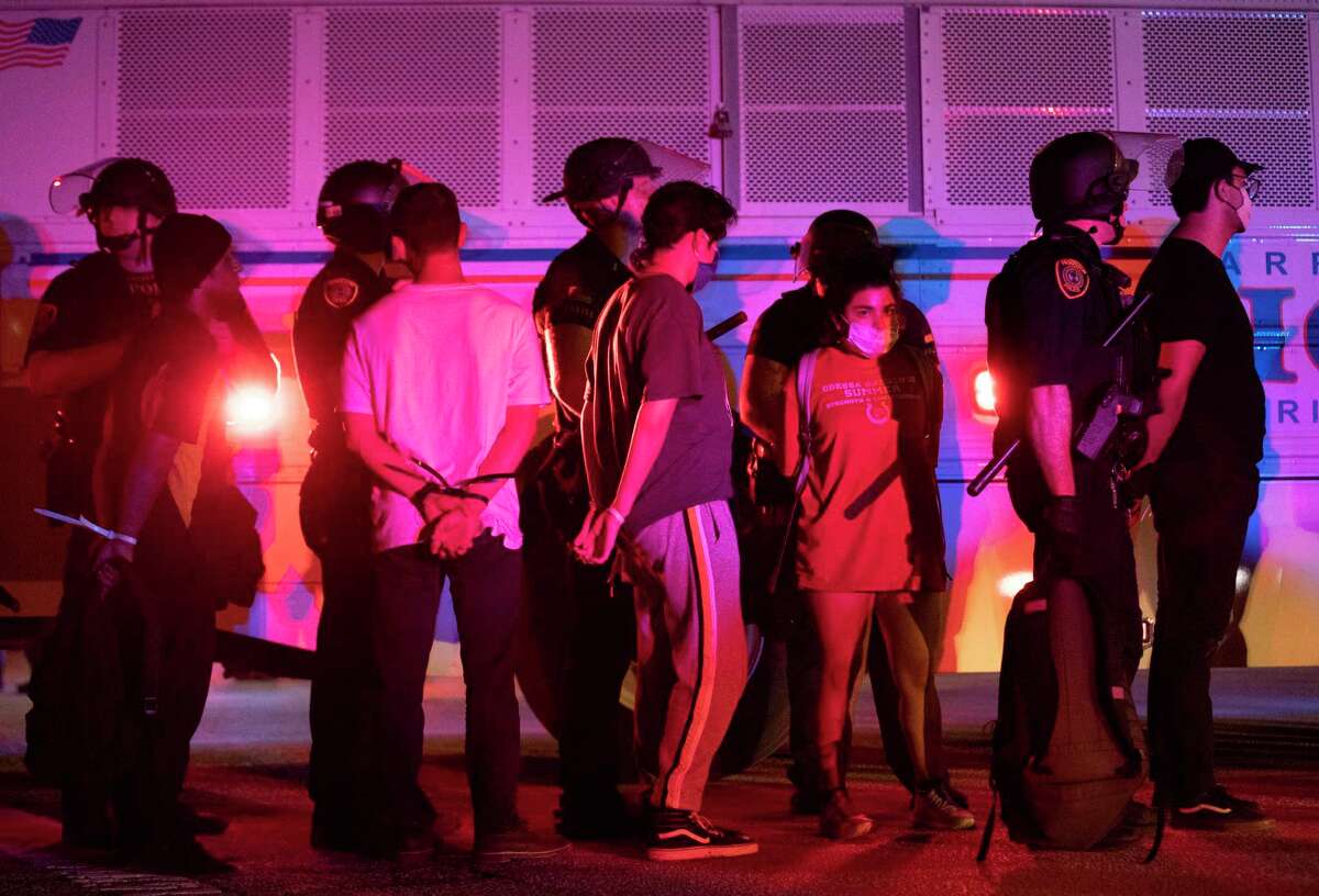 Protesters with handcuffs are detained on Tuesday, June 2, 2020, in downtown Houston during the fifth night of protests across the nation sparked by the death of former Houston resident George Floyd.
