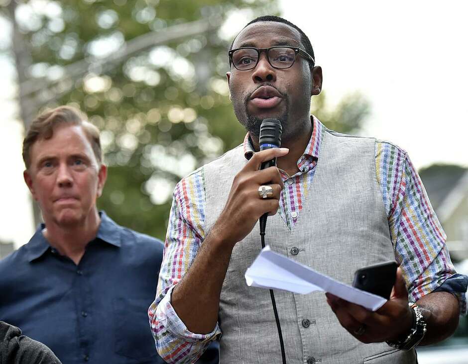 Pastor Kelcy Steele of Varick Memorial AME Zion Church leads the marchers in a prayer remembering Trayvon Foster, who was killed by gunfire near the intersection of Dixwell Avenue and Henry Street in 2018. Behind Pastor Steele is now-Gov. Ned Lamont, who was then the Democratic  candidate for governor.