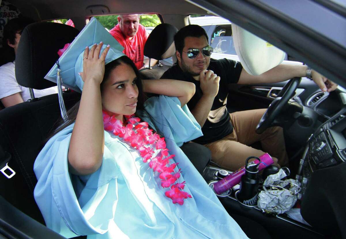 Graduate Melissa Cabezas adjust her graduation cap inside the family vehicle during Oxford High School's Class of 2020 Commencement in Oxford, Conn., on Tuesday June 9, 2020. Oxford is one of the first graduations in Connecticut to be held in the midst of the COVID-19 pandemic.