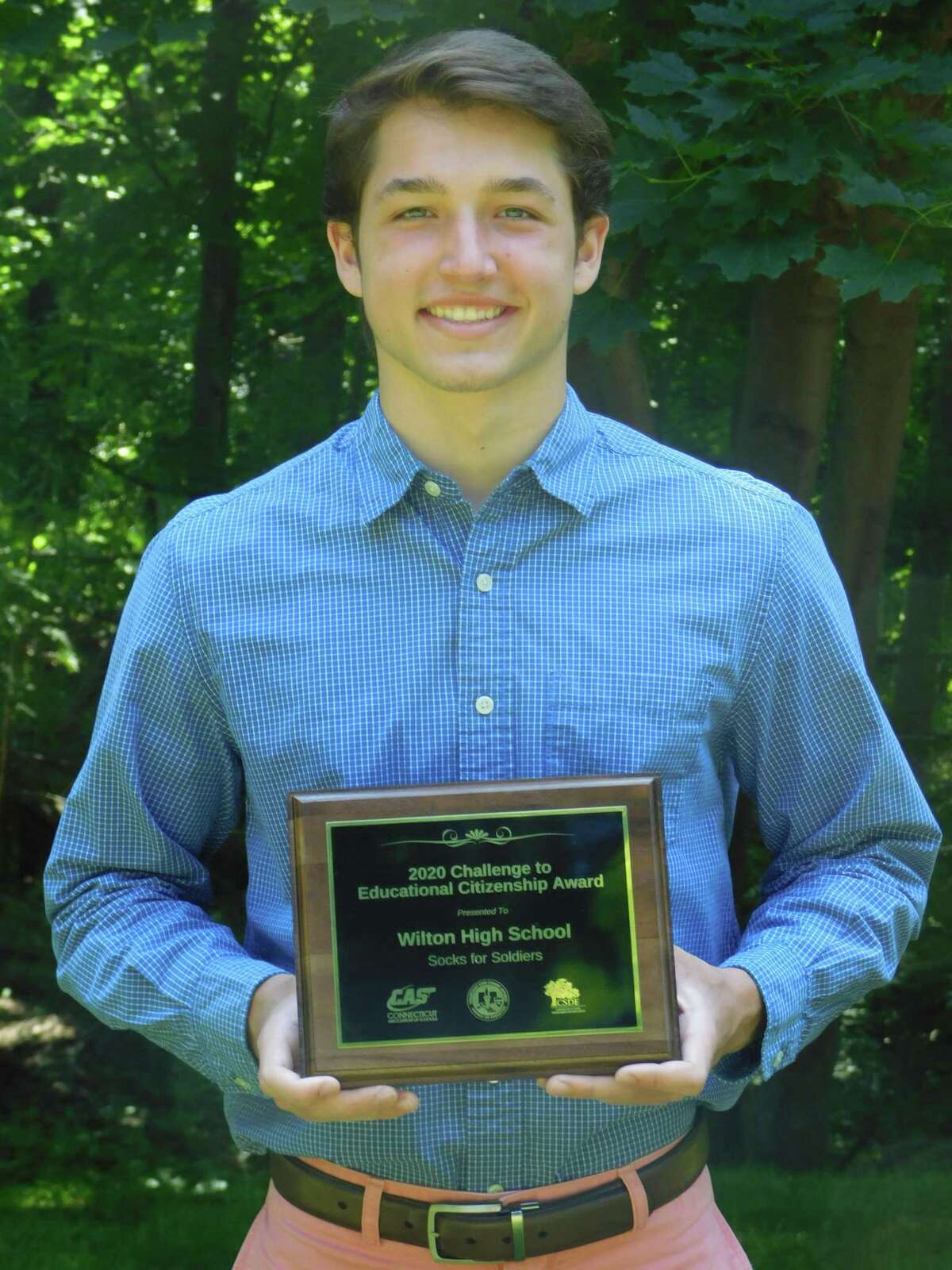 Wilton High School senior Jake Zeyher holds a Connecticut Association of Schools award for the Socks for Soldiers program that was given out virtually on June 9.