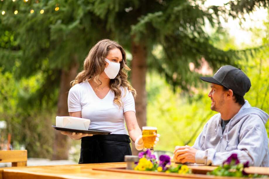 FILE-- A sign at the outdoor host stand asks diners to wear a mask at La Voile on Newbury Street in Boston on June 8, 2020. As San Francisco restaurants begin to offer outdoor dining, health safety steps will need to be implemented amid the coronavirus pandemic. Photo: StockstudioX/Getty Images