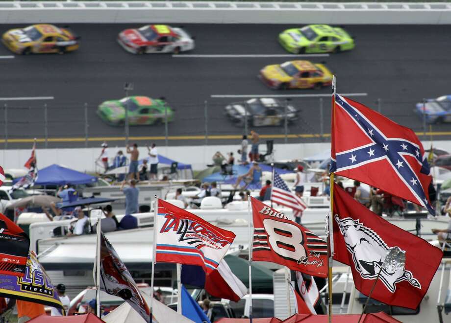A Confederate flag flies in the infield as cars come out of Turn 1 during a NASCAR auto race at Talladega Superspeedway in Talladega, Ala., in 2007. NASCAR banned the Confederate flag from its races and venues on Wednesday, June 10, 2020, formally severing itself from what for many is a symbol of slavery and racism. Photo: Rob Carr / Associated Press 2007