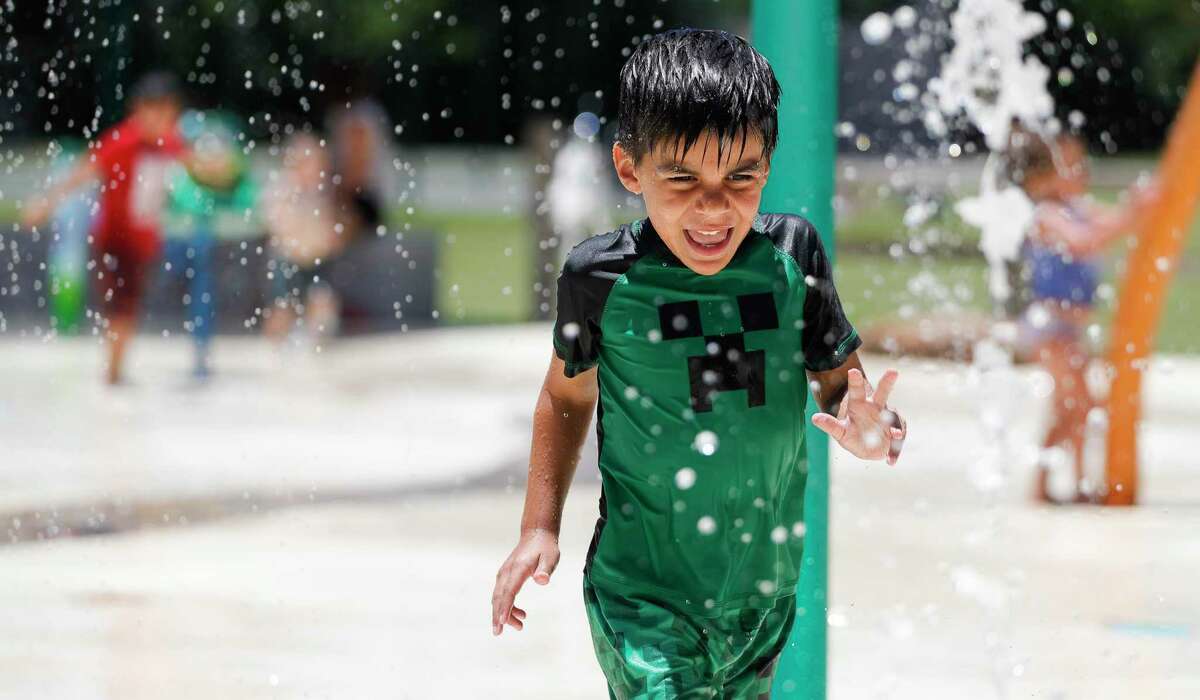 Grayson Loveless yells as he runs through water during a visit to the splash park at Martin Luther King, Jr. Park, Wednesday, June 10, 2020, in Conroe.