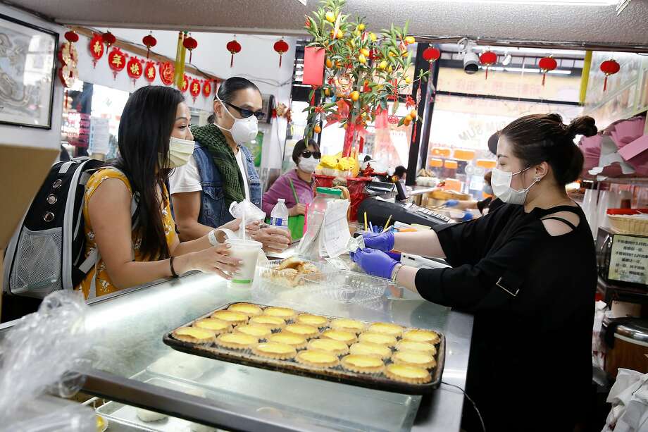 S.F. Peace Collective member J. Jiang (left) and collective founder Max Leung talk with Ying Huang, owner House of Dim Sum, as they grab a bite to eat while patrolling in Chinatown in April. Photo: Lea Suzuki / The Chronicle