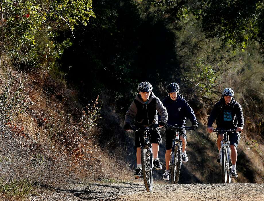 With 8-year-old Ari Kaufman leading the way, Ryan Loften takes some students for a ride near Phoenix Lake in Ross in 2013. Photo: Brant Ward / The Chronicle 2013