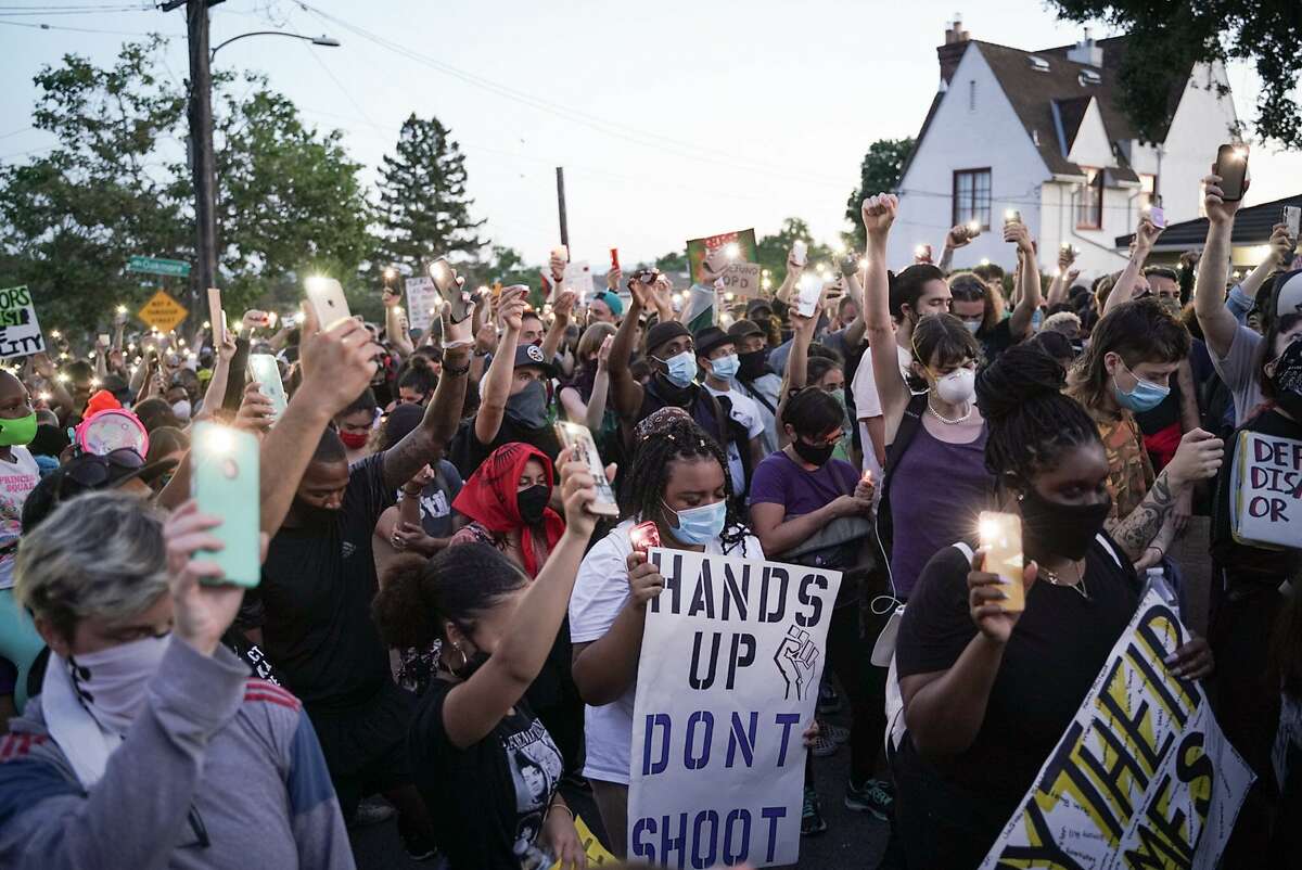 Demonstrators light candles during a youth led protest to defund the Oakland Police Department in front of Mayor Libby Schaaf’s house in Oakland, Calif., on Wednesday, June 10, 2020.